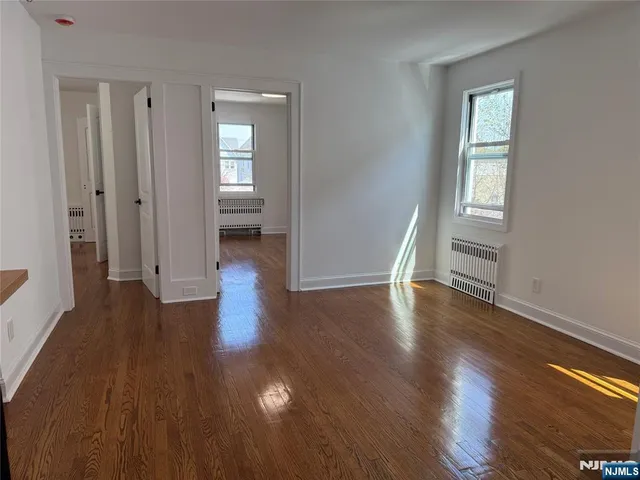 a view of a hallway with wooden floor and stairs