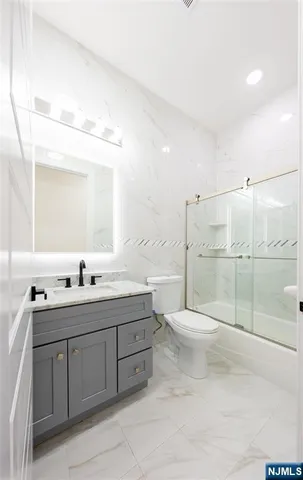 a bathroom with a double vanity sink toilet and shower