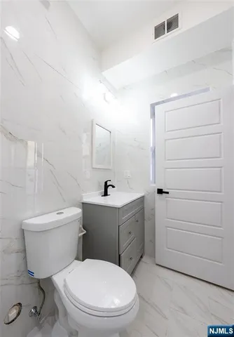 a white toilet sitting next to a bathroom sink