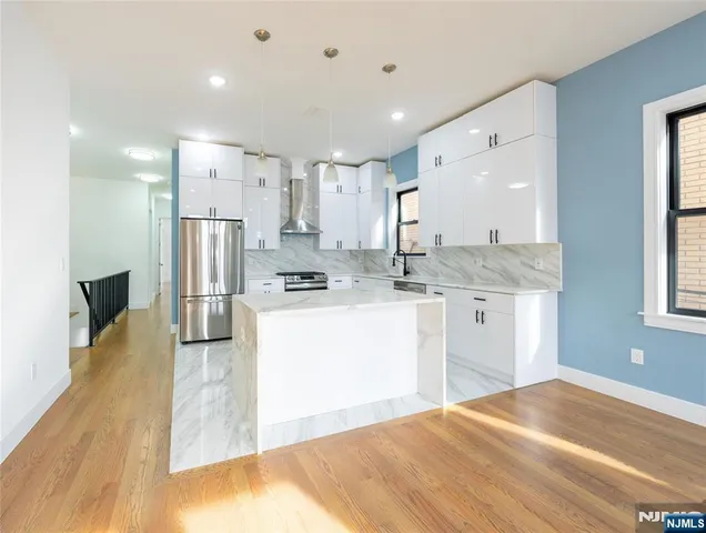 a kitchen with kitchen island a sink appliances and cabinets