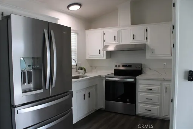 a kitchen with white cabinets and stainless steel appliances