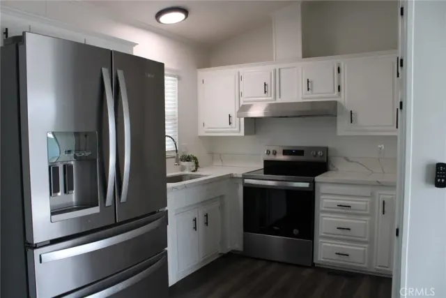 a kitchen with stainless steel appliances white cabinets and a refrigerator