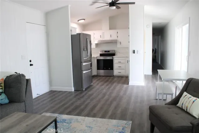 a kitchen with stainless steel appliances a refrigerator and wooden floor