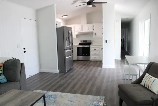 a kitchen with stainless steel appliances a refrigerator and wooden floor