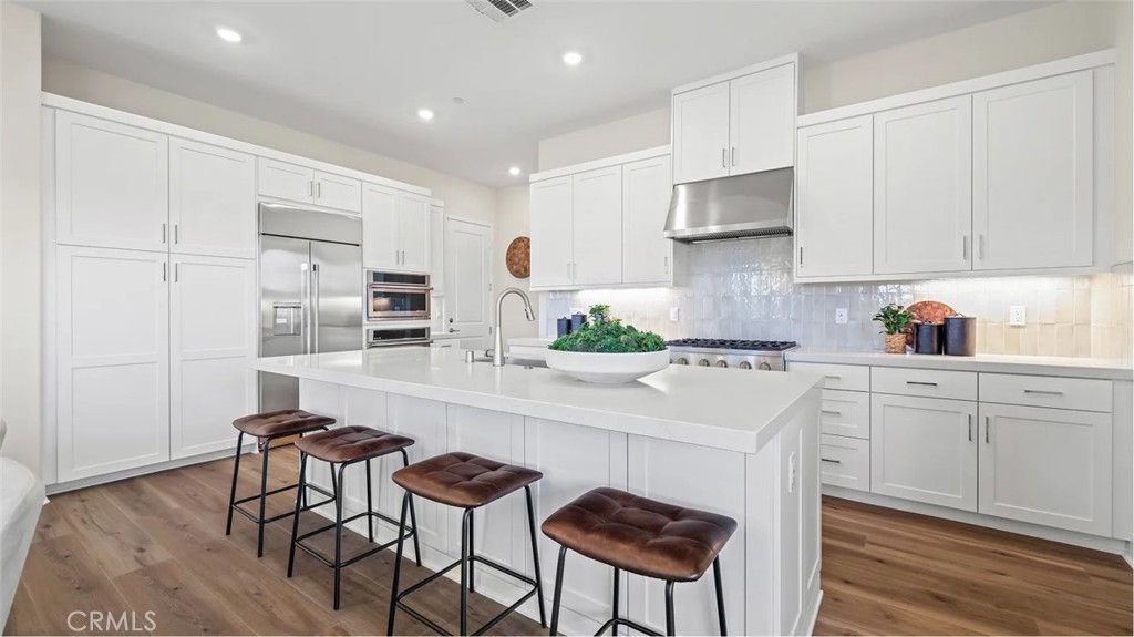 1379 Gavilan Ridge Rancho Mission Viejo, CA 92694 - Photo 2 of 27 a kitchen with stainless steel appliances white cabinets and wooden floor