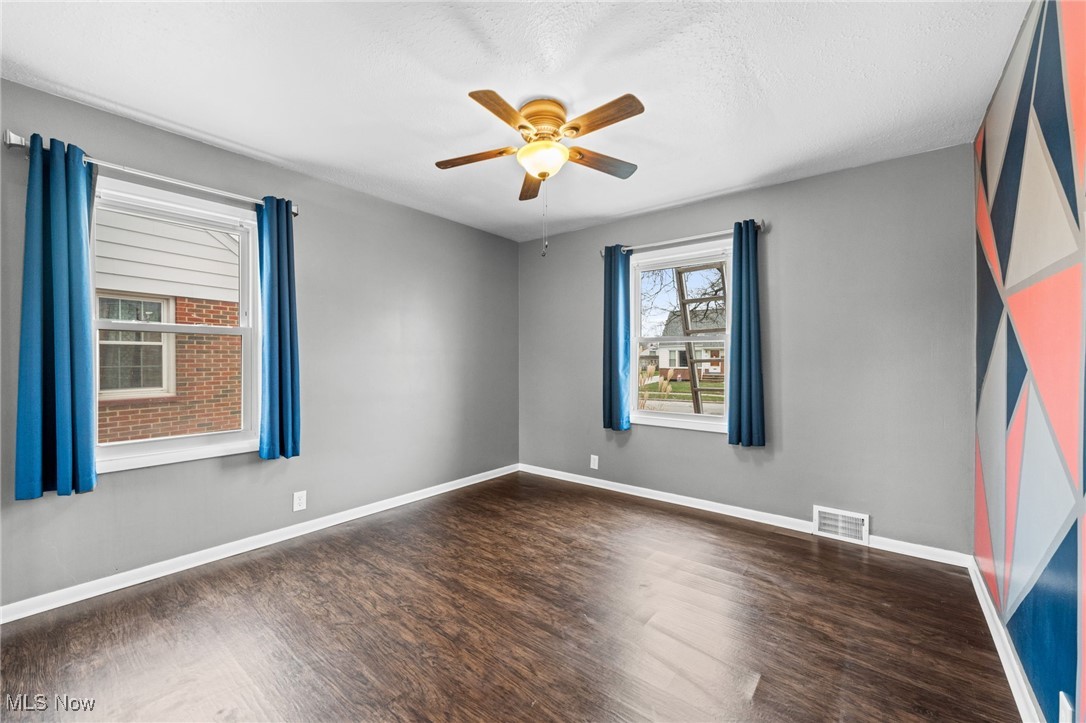 625 Pendley Road Willowick, OH 44095 - Photo 13 of 28 Spare room featuring dark wood-style flooring and a ceiling fan