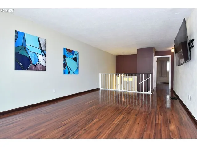 a view of a hallway with wooden floor and furniture