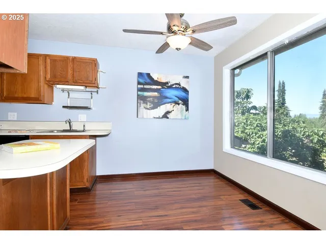 a view of kitchen with stainless steel appliances granite countertop a stove a sink and a large window