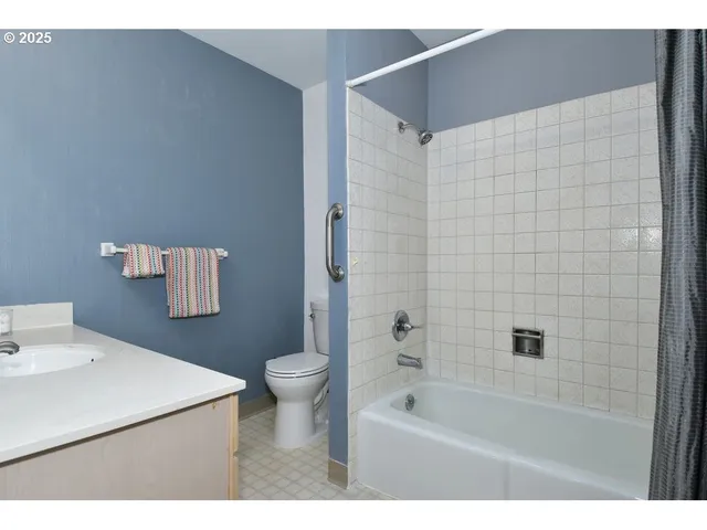 a bathroom with a bathtub sink vanity mirror and toilet