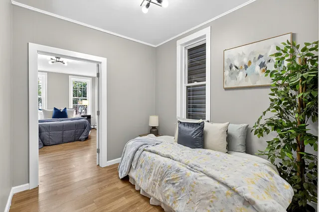 a bedroom with a large bed and a potted plant