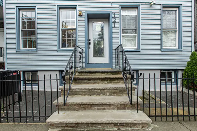 a front view of a house with a tree