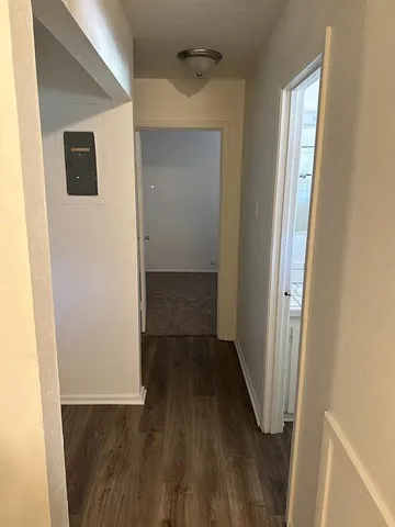a view of a hallway with wooden floor and closet