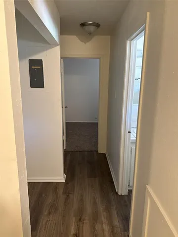 a view of a hallway with wooden floor and closet