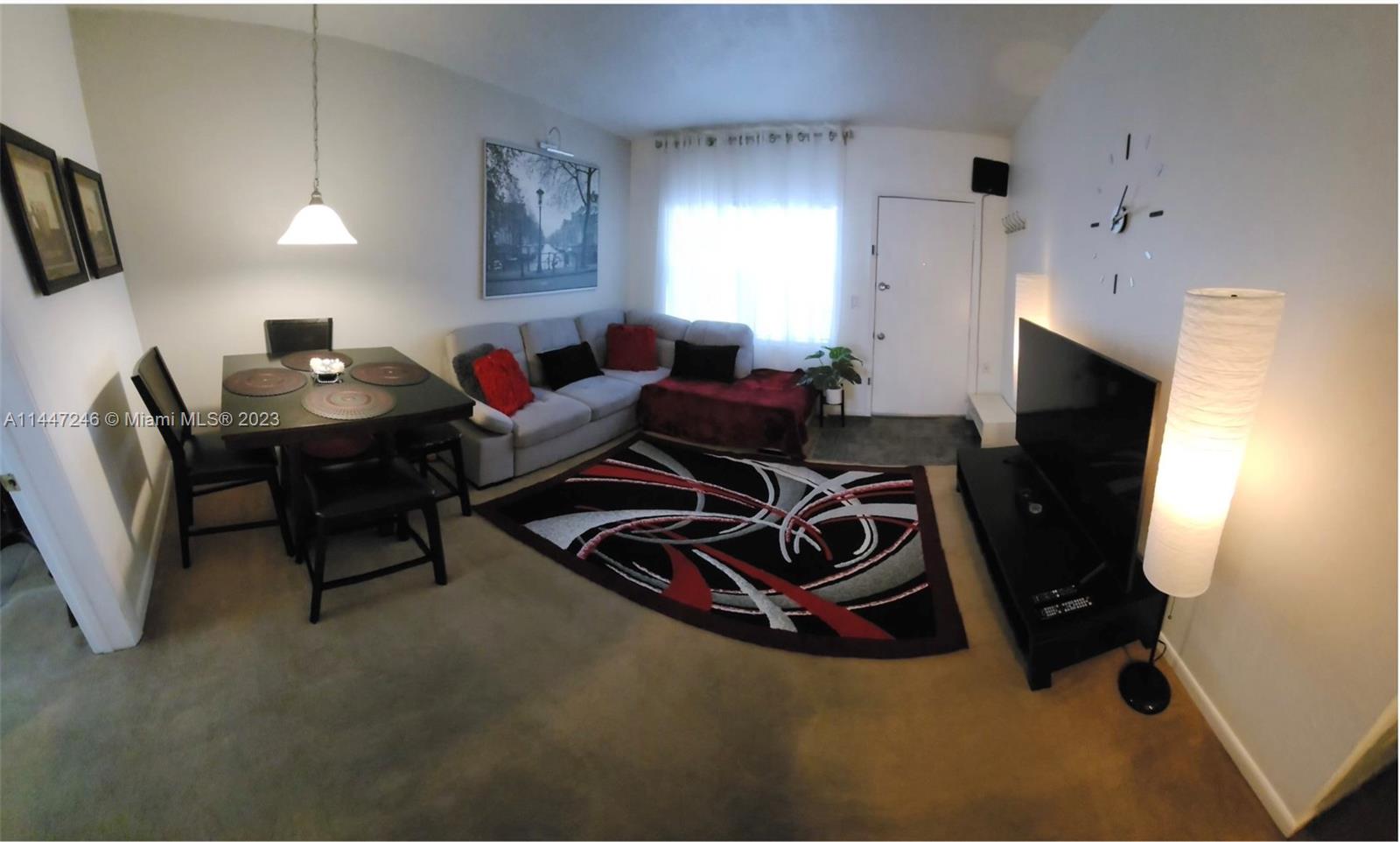 a living room with furniture window and a flat screen tv