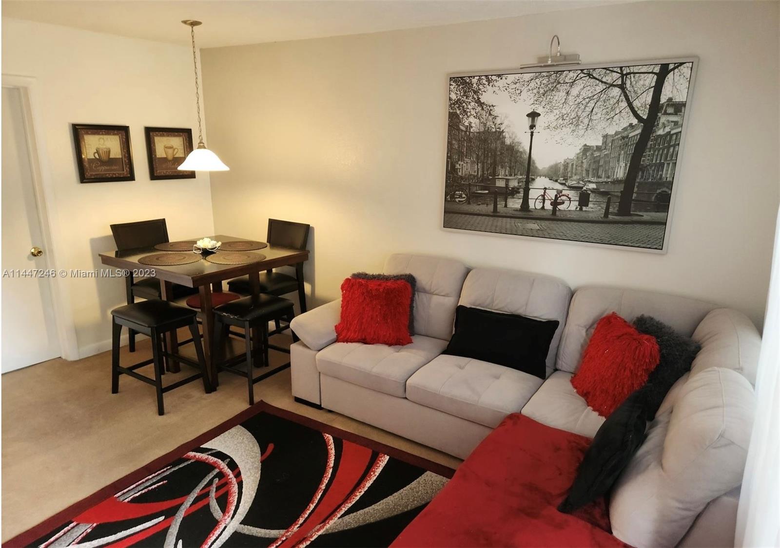 770 Ridenhour Circle, Unit 770 Orlando, FL 32809 - Photo 3 of 10 a living room with furniture and a flat screen tv with the kitchen view