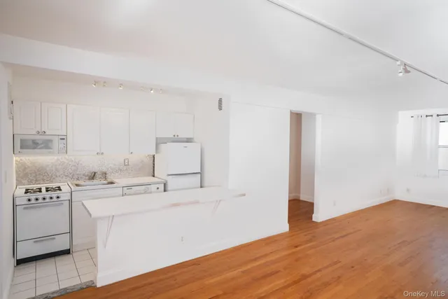 a kitchen with a sink cabinets and wooden floor