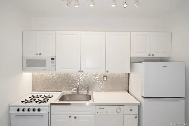 a kitchen with white cabinets and white appliances