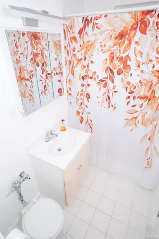 a bathroom with a sink a toilet and shower curtain