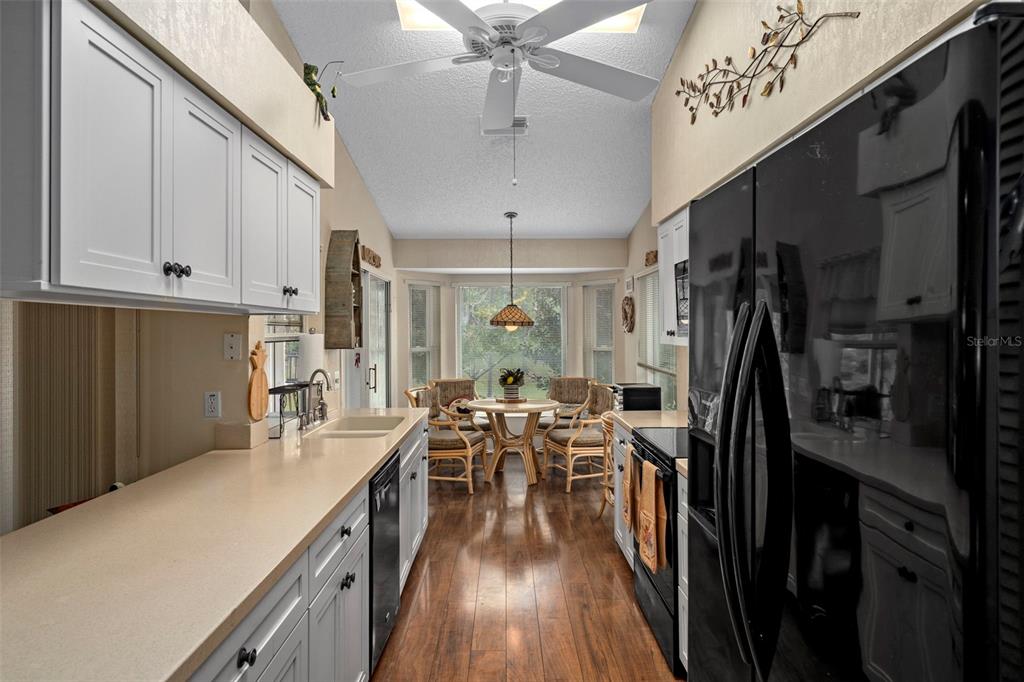 2102 Springmeadow Drive Spring Hill, FL 34606 - Photo 12 of 41 a kitchen with stainless steel appliances a refrigerator a sink dishwasher a stove and white cabinets with wooden floor
