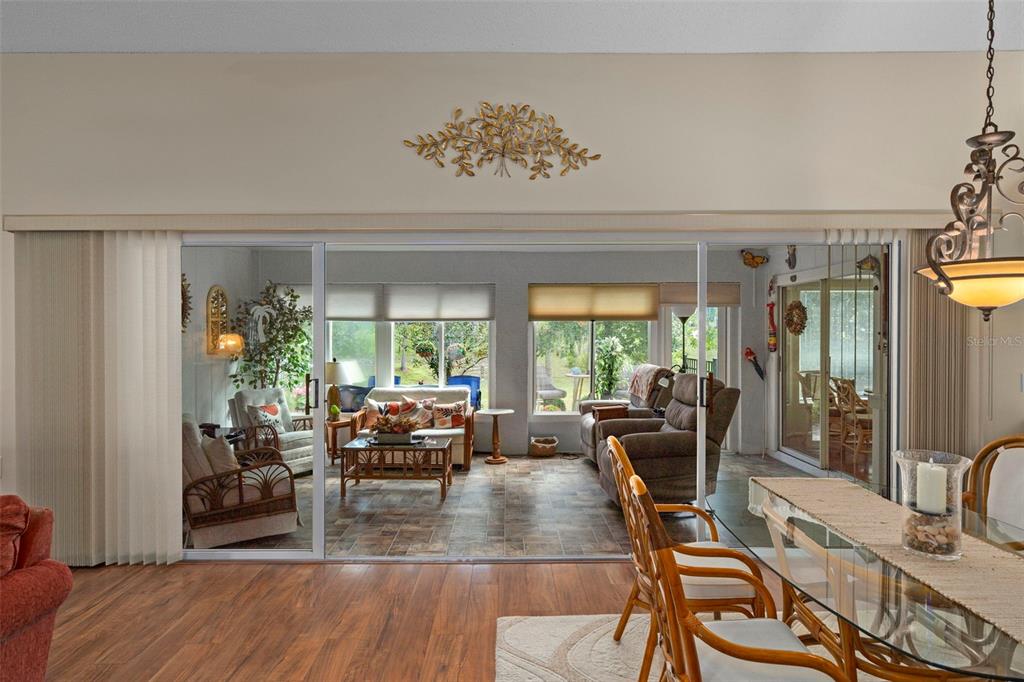 2102 Springmeadow Drive Spring Hill, FL 34606 - Photo 8 of 41 a view of a dining room with furniture large windows and wooden floor