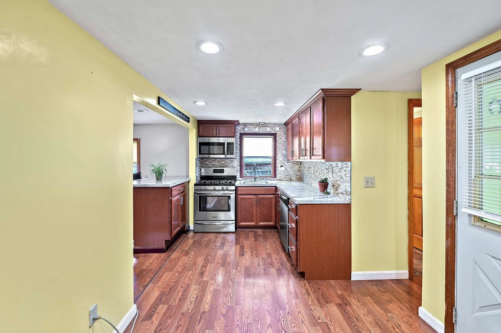 21 Alder Road Holbrook, MA 02343 - Photo 7 of 23 a kitchen with stainless steel appliances a refrigerator and a wooden floor