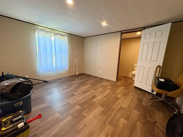 a view of room with wooden floor and furniture