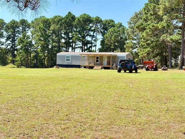a view of an ocean with a big yard and large trees