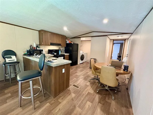 a work room with furniture a rug and a window