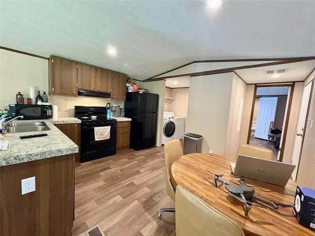 a kitchen with kitchen island a counter top space a sink stainless steel appliances and cabinets