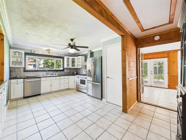 a large white kitchen with a stove a sink dishwasher and a refrigerator
