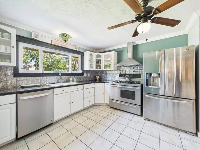 a kitchen with stainless steel appliances granite countertop a stove a sink and a refrigerator