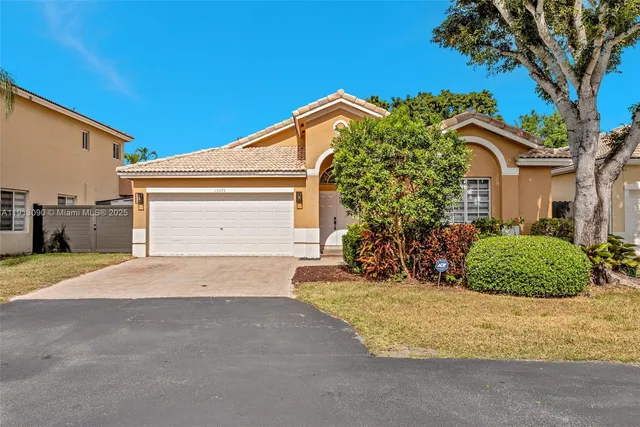 a view of a house with a yard and potted plants