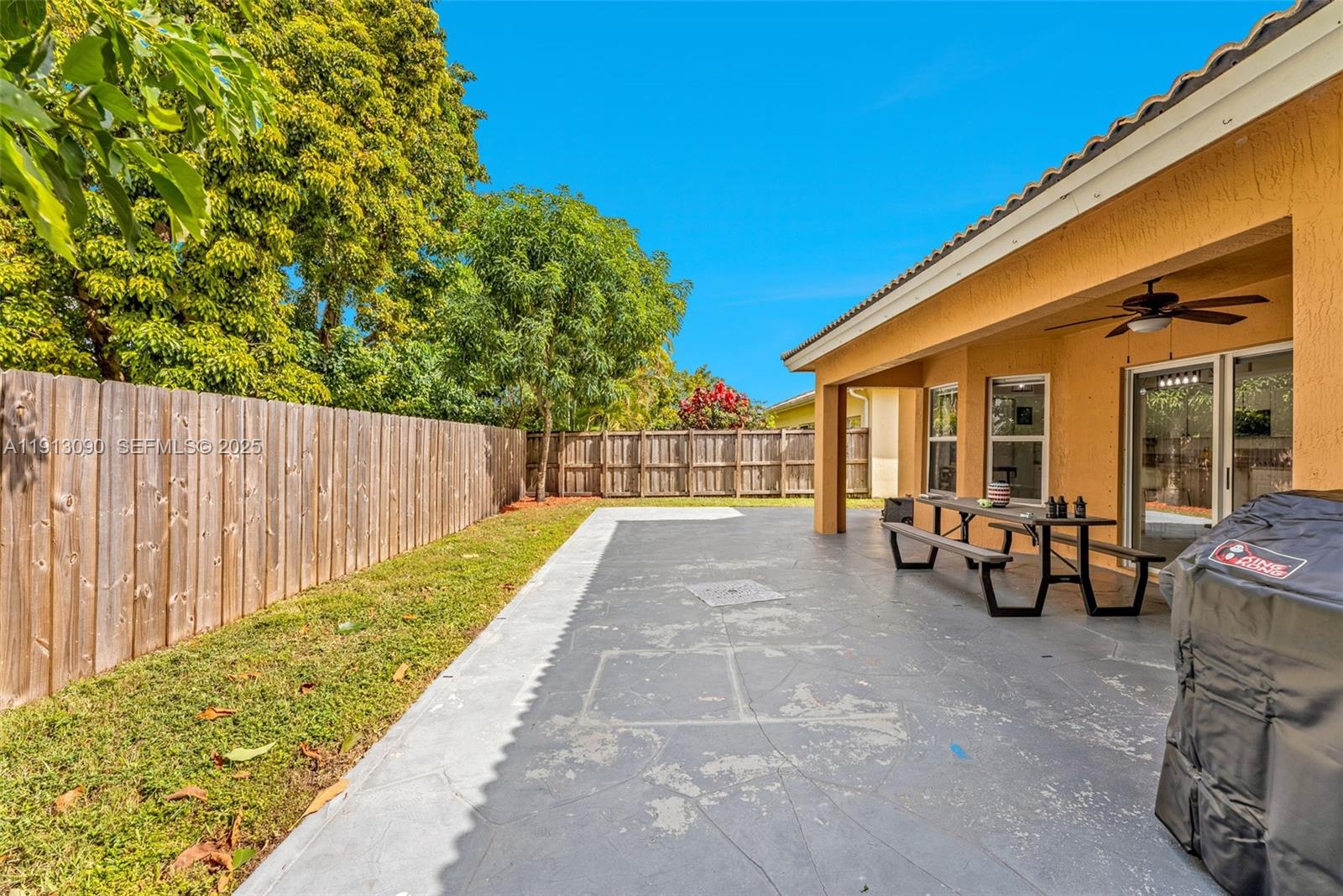 15475 Southwest 138th Terrace Miami, FL 33196 - Photo 28 of 31 a view of a patio with table and chairs potted plants with wooden fence