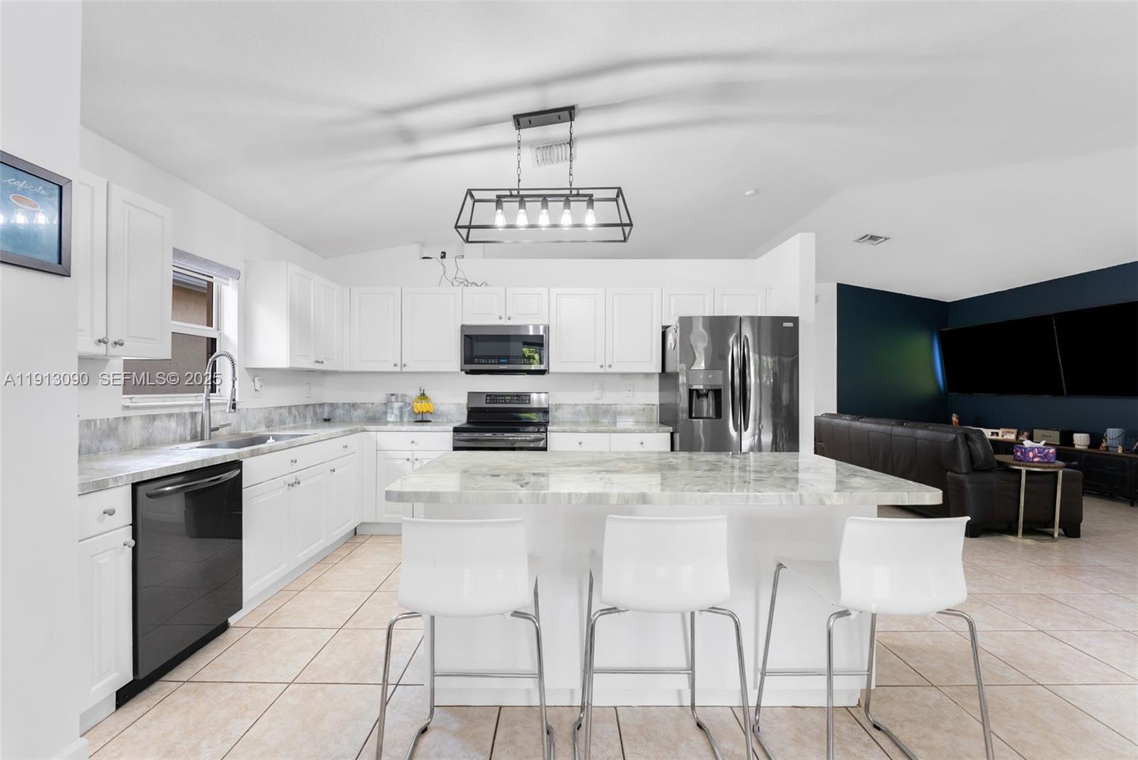 15475 Southwest 138th Terrace Miami, FL 33196 - Photo 10 of 31 a kitchen with stainless steel appliances kitchen island granite countertop a stove and cabinets