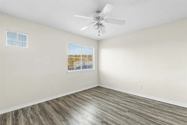 an empty room with a window and a ceiling fan