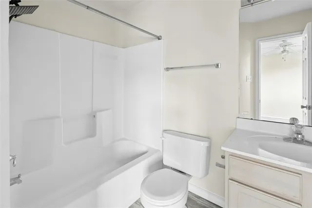a white toilet sitting next to a bath tub