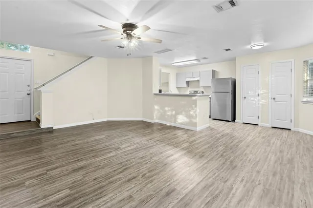 a view of a kitchen with a sink dishwasher a refrigerator and wooden floor