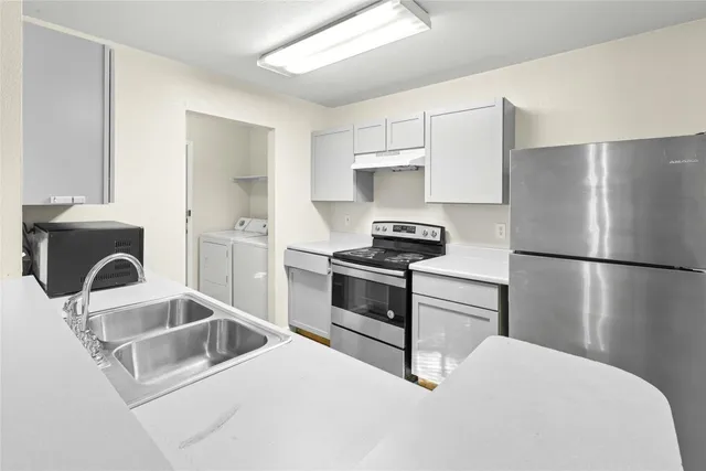 a kitchen with a refrigerator stove and sink