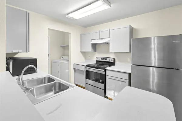 a kitchen with a refrigerator and a sink