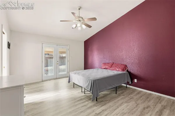 a bedroom with a bed chandelier and a window