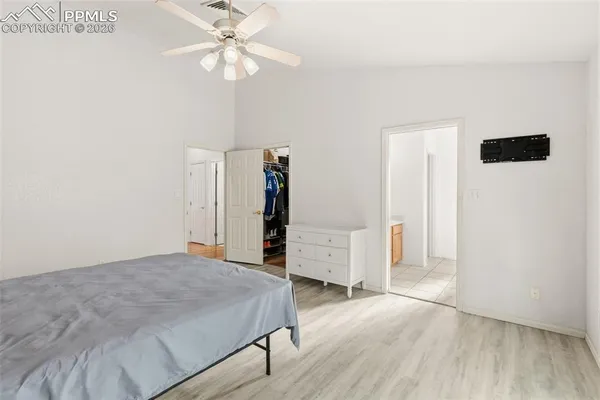 a bedroom with a bed and a ceiling fan