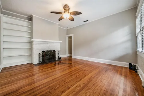a view of empty room with wooden floor and fireplace