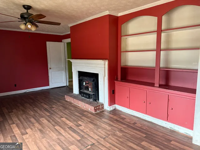 a view of an empty room with a fireplace and a window