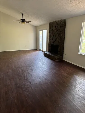 an empty room with windows and a fireplace