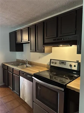 a kitchen with wooden cabinets and a stove top oven