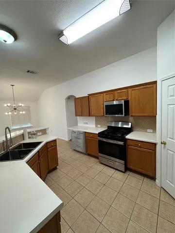 an empty room with wooden floor ceiling fan and windows