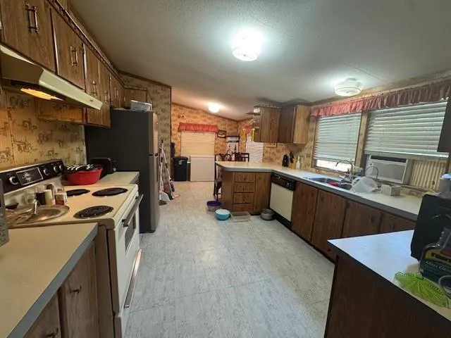 a kitchen with a sink dishwasher stove and refrigerator