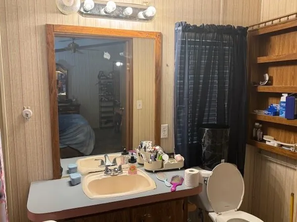 a bathroom with a sink vanity mirror and toilet