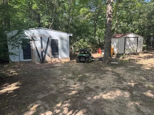 a view of a house with backyard and a tree
