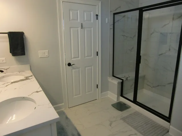 a bathroom with a sink and glass door shower